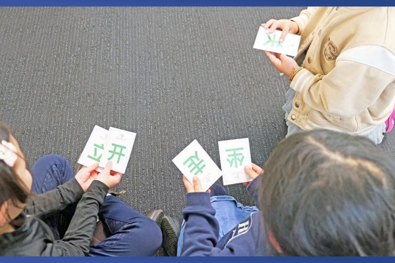 澳升教育课堂上小学生使用汉字识字卡进行游戏化学习
