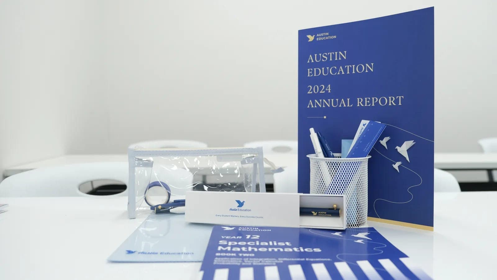 Austin Education workbooks, stationery and the 2024 annual report on a classroom desk